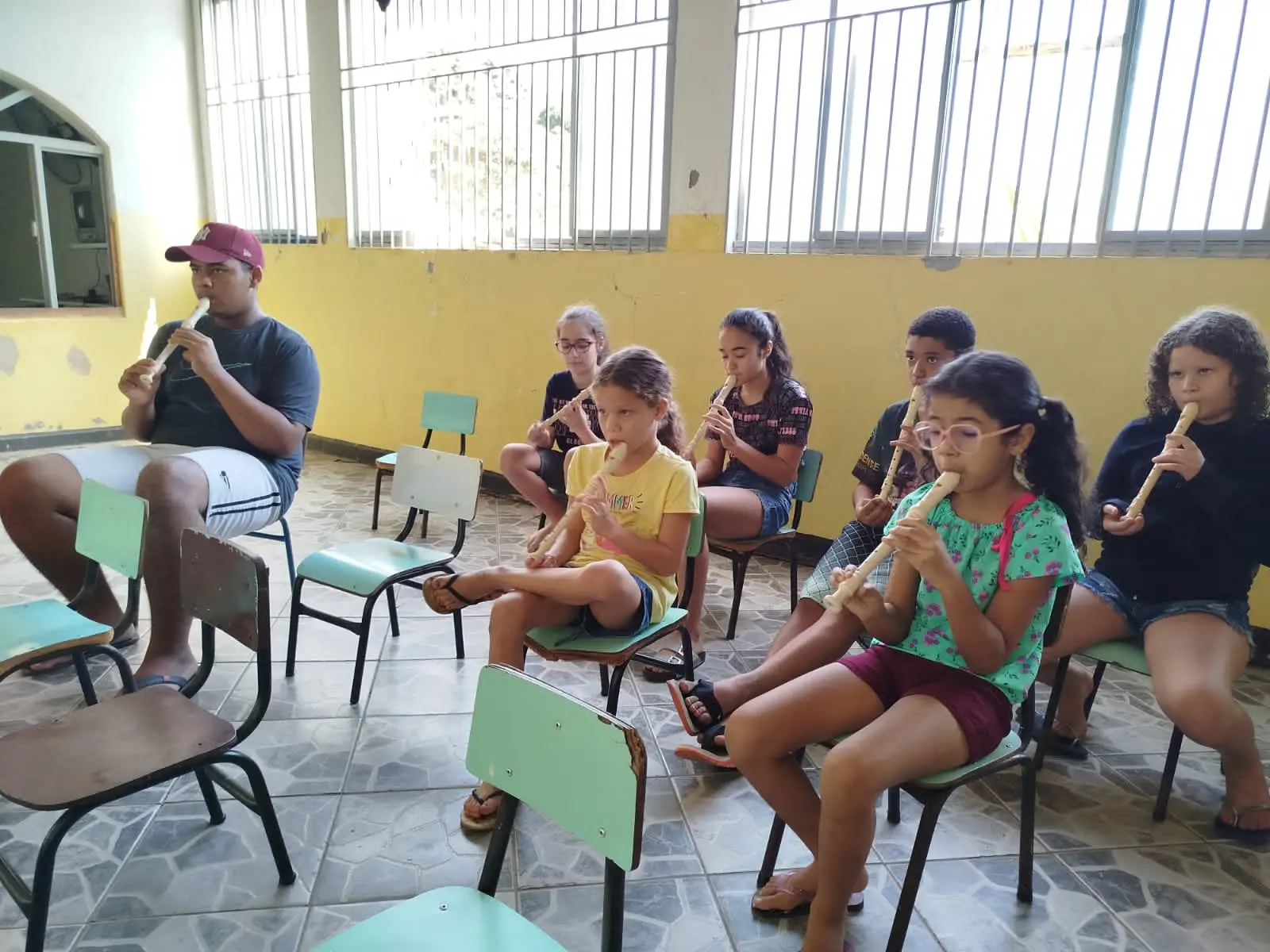 Crianças em aula coletiva de flauta